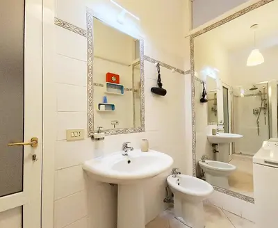 a bathroom with a sink and a toilet and a mirror at LAVINIA VATICAN HOME in Rome