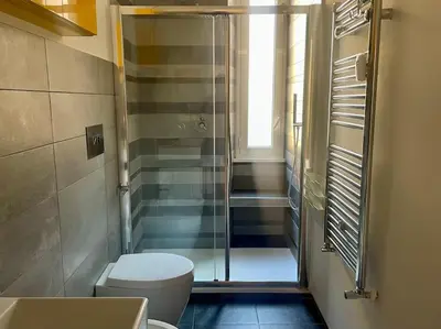 a bathroom with a toilet and a glass shower at Il Nido Apartment in Rome