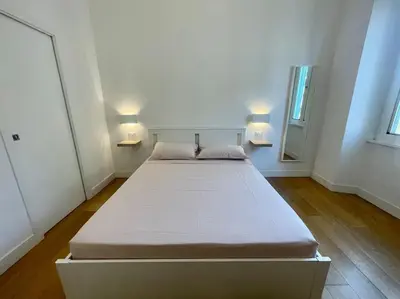 a large bed in a room with two lamps on the wall at Il Nido Apartment in Rome