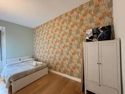 a bedroom with a bed and a floral wall at Il Nido Apartment in Rome