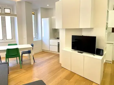 a living room with a television and a kitchen with a table at Il Nido Apartment in Rome