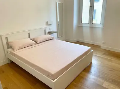a large white bed in a room with a window at Il Nido Apartment in Rome