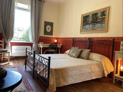 a bedroom with a bed and a table and a window at DOMUS ANNIA Guest House, The Amazing Colosseum in Rome