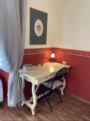 a desk with a chair in a room with a curtain at DOMUS ANNIA Guest House, The Amazing Colosseum in Rome
