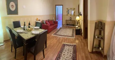a living room with a table and a red couch at DOMUS ANNIA Guest House, The Amazing Colosseum in Rome