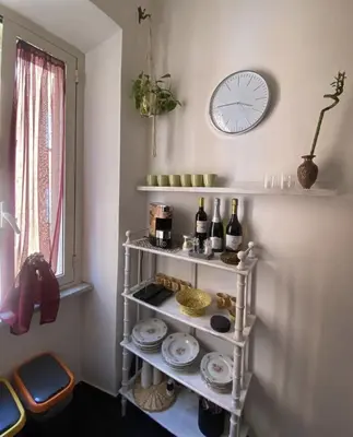 a shelf with bottles of wine and a clock on a wall at DOMUS ANNIA Guest House, The Amazing Colosseum in Rome