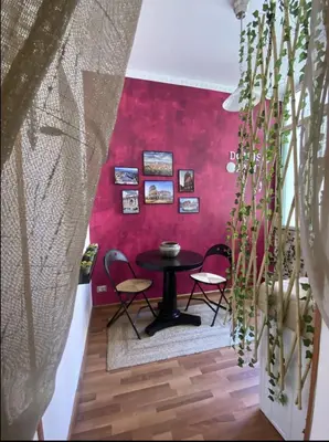 a dining room with a table and chairs against a red wall at DOMUS ANNIA Guest House, The Amazing Colosseum in Rome