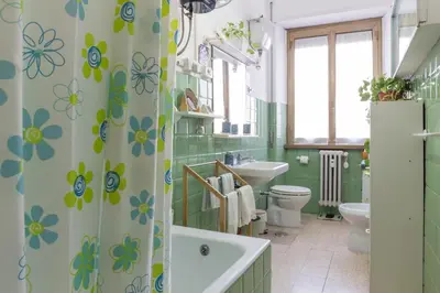 a bathroom with a shower curtain with flowers on it at Claudia B&B in Rome