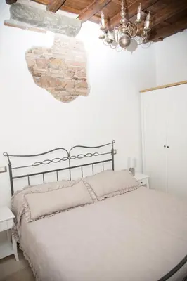 a bedroom with a bed and a stone wall at Casa vacanza Colosseo 2 in Rome