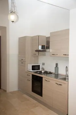 a kitchen with wooden cabinets and a stove top oven at Casa vacanza Colosseo 2 in Rome