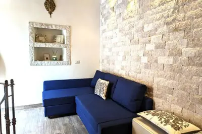a blue couch in a room with a brick wall at Trastevere's Nest in Rome