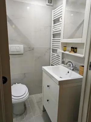 a white bathroom with a toilet and a sink at Trastevere's Nest in Rome
