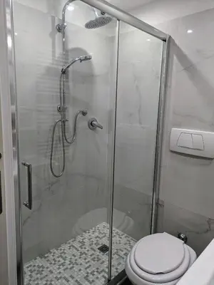 a bathroom with a glass shower with a toilet at Trastevere's Nest in Rome