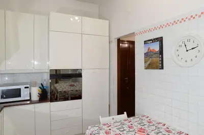 a kitchen with a microwave and a clock on the wall at Emilios home Triple room in our cozy and comfortable establishment in Rome