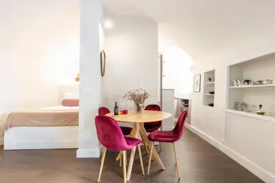 a dining room with a table and pink chairs at Relax Campo de' Fiori in Rome