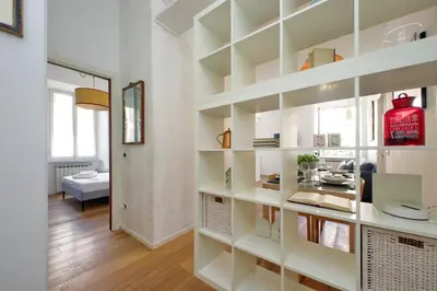 a room with white bookshelves and a living room at Segneri Viale Trastevere in Rome