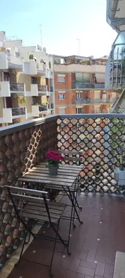 a table with a potted plant on a balcony at Frank Host Roma Lux , Metro A a 50 m, simple check-in con codice a qualsiasi orario in Rome