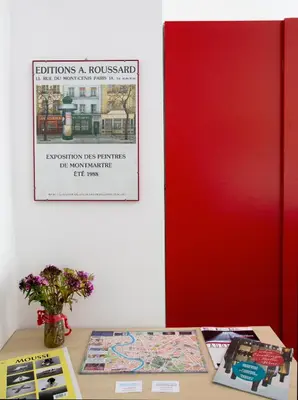 a table with books and a poster on a wall at Ulysses in Rome in Rome