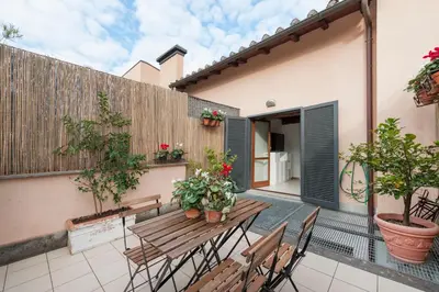 a patio with a wooden table and chairs at Charming patio house in San Lorenzo in Rome
