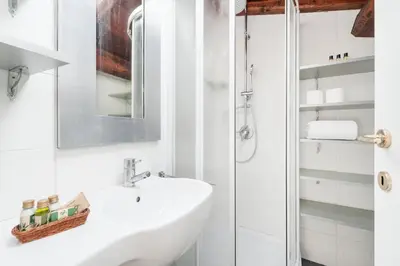 a white bathroom with a sink and a shower at Charming patio house in San Lorenzo in Rome