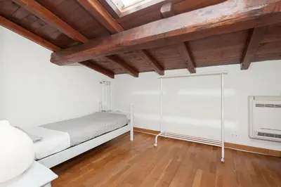 a bedroom with white walls and a wooden ceiling at Charming patio house in San Lorenzo in Rome