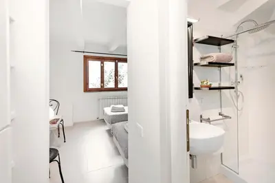 a white bathroom with a sink and a mirror at Charming patio house in San Lorenzo in Rome