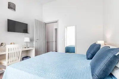 a bedroom with a blue bed with a tv on the wall at APARTMENT IN TRASTEVERE in Rome