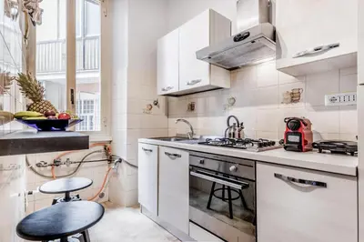a white kitchen with a stove and a sink at APARTMENT IN TRASTEVERE in Rome