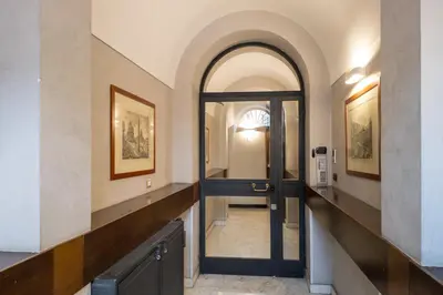 a hallway with a door leading to a hallway with paintings at Penthouse Suite Rome - Private Suites in Rome