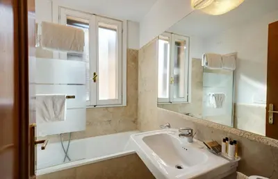 a bathroom with a sink and a tub and a mirror at Penthouse Suite Rome - Private Suites in Rome