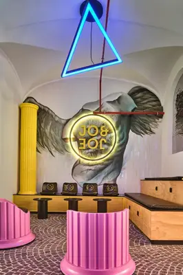 a restaurant with tables and chairs in a room with blue walls at JO&JOE ROMA in Rome