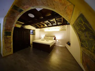 a bedroom with a bed in a room with an archway at Tre Colonne in Rome