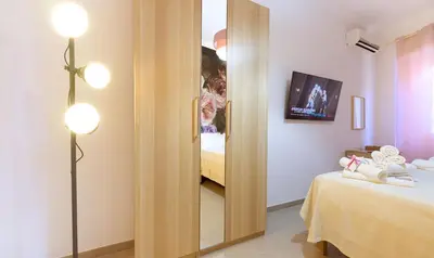 a room with a mirror next to a bed and a room at PeoniaMaximaHouse -Piazza Bologna- in Rome