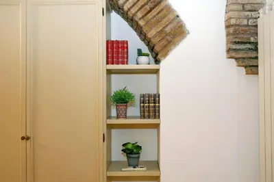 a room with a shelf with plants and books at luxury home trastevere in Rome