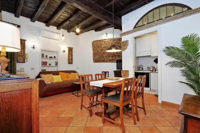 a kitchen and living room with a table and chairs at luxury home trastevere in Rome