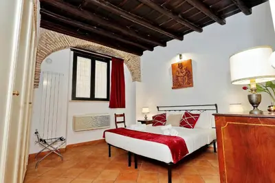 a bedroom with a large bed with a red blanket at luxury home trastevere in Rome
