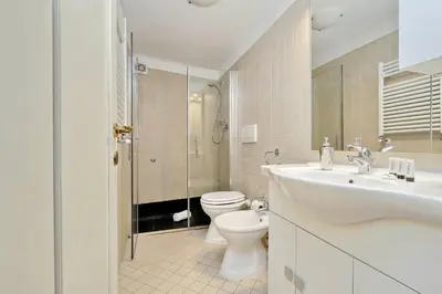 a white bathroom with a toilet and a sink at luxury home trastevere in Rome