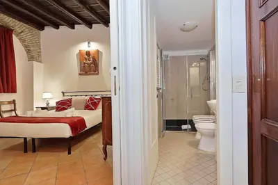 a bedroom with a bed and a bathroom with a toilet at luxury home trastevere in Rome