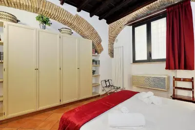 a bedroom with a large bed with a red blanket at luxury home trastevere in Rome