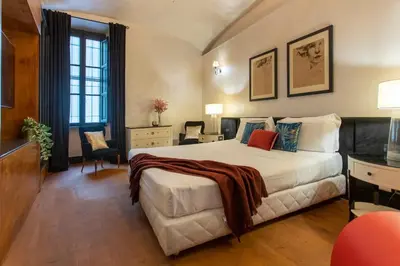 a hotel room with a large bed and a desk at Cloe Suite - A due passi da Villa Borghese in Rome