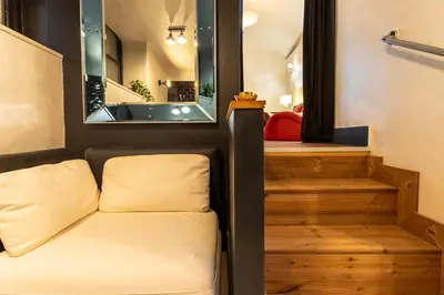a room with a chair and stairs with a mirror at Cloe Suite - A due passi da Villa Borghese in Rome