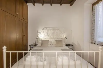 a bedroom with a white bed with a metal headboard at Happy Trastevere in Rome in Rome