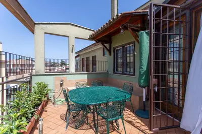 a patio with a table and chairs on a balcony at Aurelia - Roof Garden close to Vatican in Rome