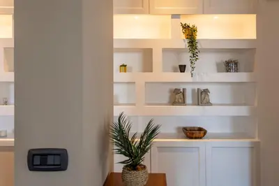 a living room with white shelves and a plant at Aurelia - Roof Garden close to Vatican in Rome