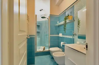 a blue bathroom with a toilet and a sink at Aurelia - Roof Garden close to Vatican in Rome
