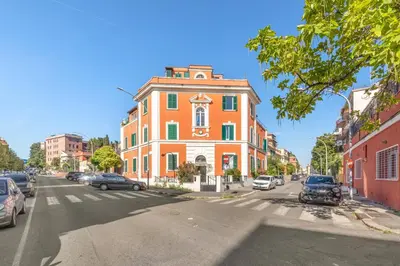 an orange building on a city street with cars parked at Fantastic Penthouse over the Roman Sky in Rome
