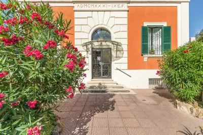 a house with pink flowers in front of it at Fantastic Penthouse over the Roman Sky in Rome