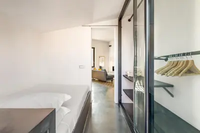a bedroom with a bed and a glass wall at Fantastic Penthouse over the Roman Sky in Rome