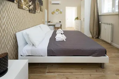a bedroom with a bed with a stuffed animal on it at Sant'Erasmo Rooms in Rome