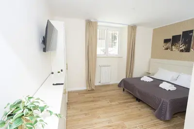 a bedroom with a bed and a tv and a staircase at Sant'Erasmo Rooms in Rome